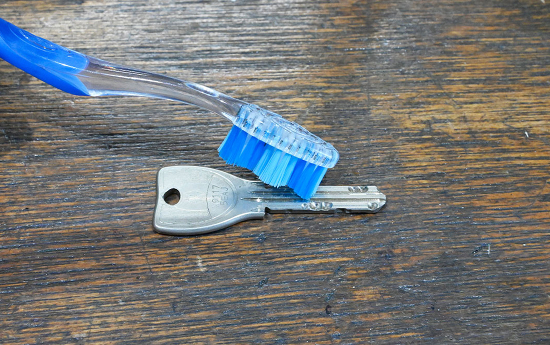 鍵の表面やくぼみに付いた汚布と歯ブラシを用意したられを落としていく